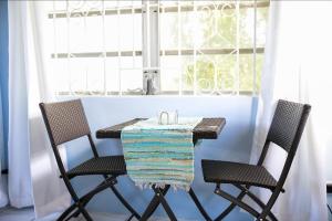 a table and two chairs in a room with a window at Tangerine Sunsets Alta Vista Studio One in Nassau