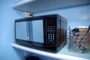 a black microwave sitting on a shelf at Tangerine Sunsets Alta Vista Studio One in Nassau