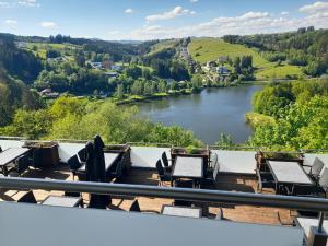 a balcony with tables and chairs and a river at Hotel - Café - Konditorei Schröckmayr-Kastner in Neufelden