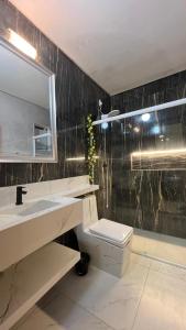 a bathroom with a sink and a toilet and a mirror at Residencial Europa in Bombinhas