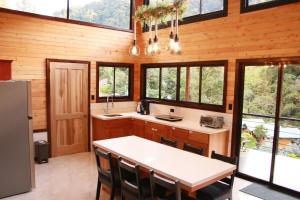a kitchen with a table and some windows at Casa Buena Vista San Gerardo de Dota in San Gerardo de Dota