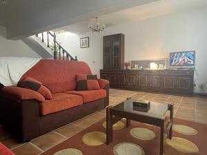 a living room with a couch and a tv at Rincón rural in Tomonde