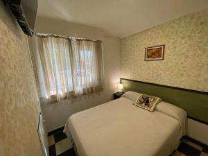 a small bedroom with a bed and a window at Hotel Messina in Mar del Plata