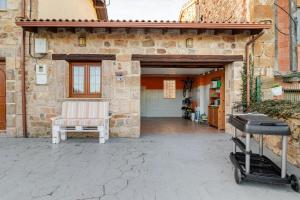 a patio with a chair and a cart in front of a building at La Regalía de Requejo in Reinosa