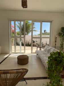 a living room with a couch and a large window at Casa Free Wind Jeri in Jericoacoara