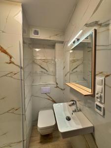 Un baño blanco con lavabo e inodoro. en Ring Apartments - Międzywodzie, en Międzywodzie