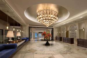 een lobby met een grote kroonluchter en een blauwe bank bij ITC Mughal, A Luxury Collection Resort & Spa, Agra in Agra