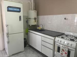 una cucina con piano cottura bianco e frigorifero di lo de fernando 2 a Río Gallegos
