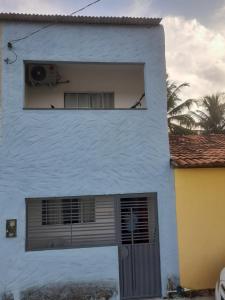 ein weißes Gebäude mit einem Fenster und einer Tür in der Unterkunft Encanto de Tatuamunha in Pôrto de Pedras