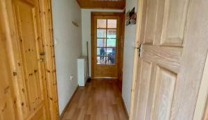 Spacious Primrose Lodge for 6 with Hot Tub at a Spa Resort في Chudleigh: ممر فارغ مع باب ونافذة