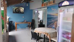 a room with a table and chairs and a wall with a painting at Pousada do Sol in Pedra de Guaratiba