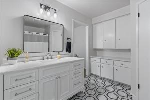 ein weißes Badezimmer mit Waschbecken und Spiegel in der Unterkunft Creekview Cottage- Events, Hot Tub, Gameroom in Round Rock + 35 Fotos