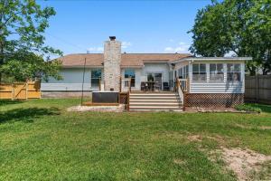 ein Haus mit einer Veranda mit einem Tisch darauf in der Unterkunft Creekview Cottage- Events, Hot Tub, Gameroom in Round Rock