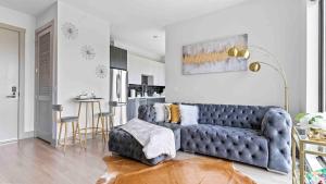 Una sala de estar con un sofá azul y una cocina. en NEW Luxury Penthouse with AmazingViews King Bed, en Atlanta