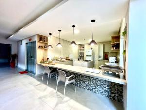 a large kitchen with a large counter with chairs at Recanto sol nascente in Rio Formoso