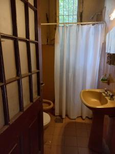 Un baño con una cortina de ducha blanca y un inodoro. en Chacra del Molino, en Navarro
