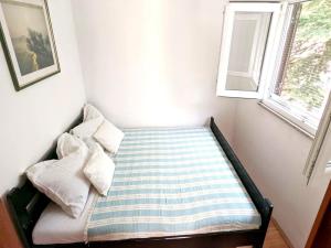 ein kleines Bett in einem Zimmer mit Fenster in der Unterkunft Holiday Home Jaga - Three bedroom Holiday Home with swimming pool in Biograd na Moru + 2 Fotos