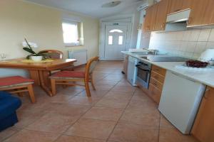- une cuisine avec des appareils blancs, une table et des chaises dans l'établissement Apartment Luka - One Bedroom Apartment with Balcony and Sea View, à Šibenik