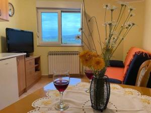 une table avec deux verres de vin et un vase de fleurs dans l'établissement Apartment Luka - One Bedroom Apartment with Balcony and Sea View, à Šibenik