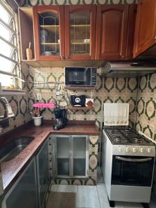 リオデジャネイロにあるPraia do Flamengoのコンロと電子レンジのある小さなキッチン