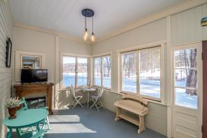 ein Raum mit Tisch und Stühlen und Fenstern in der Unterkunft Whispering Waters Farmhouse and Wedding Barn in Paris