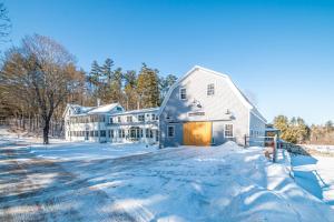 ein großes weißes Haus im Schnee in der Unterkunft Whispering Waters Farmhouse and Wedding Barn in Paris