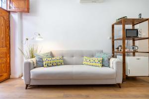 Una sala de estar con un sofá con almohadas. en Casa Miraya, en Almería