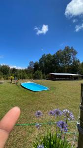 een persoon die wijst op een zwembad in een veld bij Parcela Patty in Pucura
