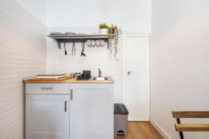 cocina blanca con encimera y fregadero en Casa Miraya, en Almería
