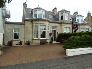 una casa grande con un banco delante en Grange View Bed and Breakfast, en Ayr