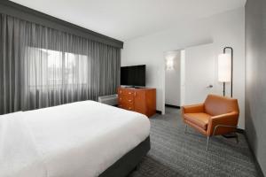 a hotel room with a bed and a chair at Courtyard by Marriott Atlanta Duluth/ Gwinnett Place in Duluth