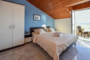 a bedroom with a large bed with blue walls at Apartments by the sea Mandre, Pag - 23187 in Kolan