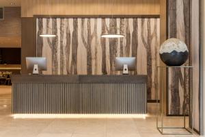 a lobby with a reception desk with a vase on display at AC Hotel by Marriott Berlin Humboldthain Park in Berlin