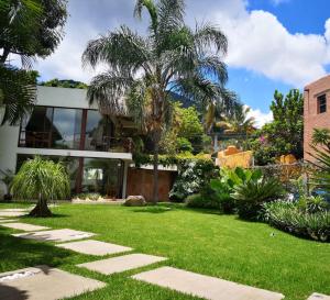 a garden with a lawn and a house at Mocca Hotels in Tepoztlán