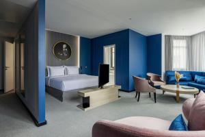 a hotel room with a bed and a tv at Hotel Luc, Autograph Collection in Berlin