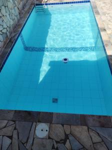 a swimming pool with blue tiles on the floor at Chácara das Oliveiras in Campinas