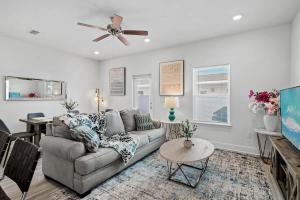 Una sala de estar con un sofá y un ventilador de techo. en B Coastal Near Cessna Landing, en Santa Rosa Beach