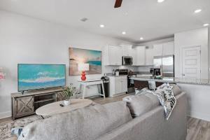Una sala de estar con un sofá y una cocina. en B Coastal Near Cessna Landing, en Santa Rosa Beach