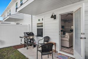 un patio con 2 sillas y una parrilla en una casa en B Coastal Near Cessna Landing, en Santa Rosa Beach