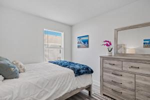 Un dormitorio con una cama y una cómoda con espejo. en B Coastal Near Cessna Landing, en Santa Rosa Beach