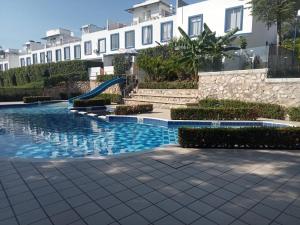 a swimming pool with a slide in front of a building at Casa mediterránea con piscina, aire, WI-FI y cocina in Carmen de Apicalá
