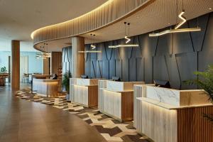 ベルリンにあるCourtyard by Marriott Berlin City Centerのデスクと椅子が備わるホテルのロビー