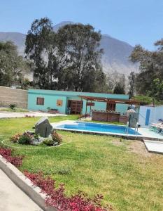 a house with a yard with a swimming pool at Villa MAS - Condominio Hacienda II in Pachacamac