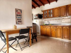 una cocina con armarios de madera y una mesa y sillas de madera. en Habitacion Multiple con baño privado, en Medellín