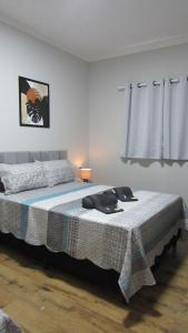 a bedroom with a bed with a blanket on it at Casa1sn - Preço de quarto com o conforto de casa! in Serra Negra