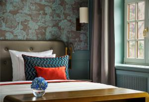 a bedroom with a bed and a table with pillows at Hotel Taschenbergpalais Kempinski in Dresden
