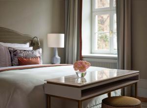 a bedroom with a bed and a table with flowers on it at Hotel Taschenbergpalais Kempinski in Dresden