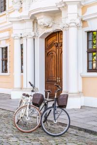 two bikes parked in front of a building with a wooden door at Hotel Taschenbergpalais Kempinski in Dresden