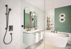 a bathroom with two sinks and a tub and a shower at Hotel Taschenbergpalais Kempinski in Dresden
