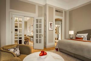a bedroom with a bed and a table with a bowl of fruit at Hotel Taschenbergpalais Kempinski in Dresden